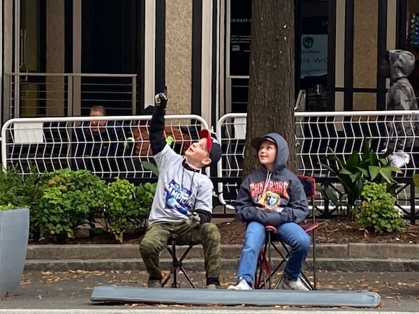 Friends Cooper Rose, 11, and Channing Pittman, 10, of Walton County, Georgia, prepare for Friday’s parade along Peachtree Street in Atlanta. The fifth graders skipped school to attend. VANESSA McCRAY/ AJC