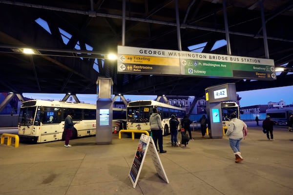 Communters wait for buses at the George Washington Bridge Bus Station in New York, Friday, Dec. 6, 2024, where the gunman fleeing Wednesday's shooting of UnitedHealthcare CEO Brian Thompson took a taxi to, according to surveillance video. (AP Photo/Richard Drew)