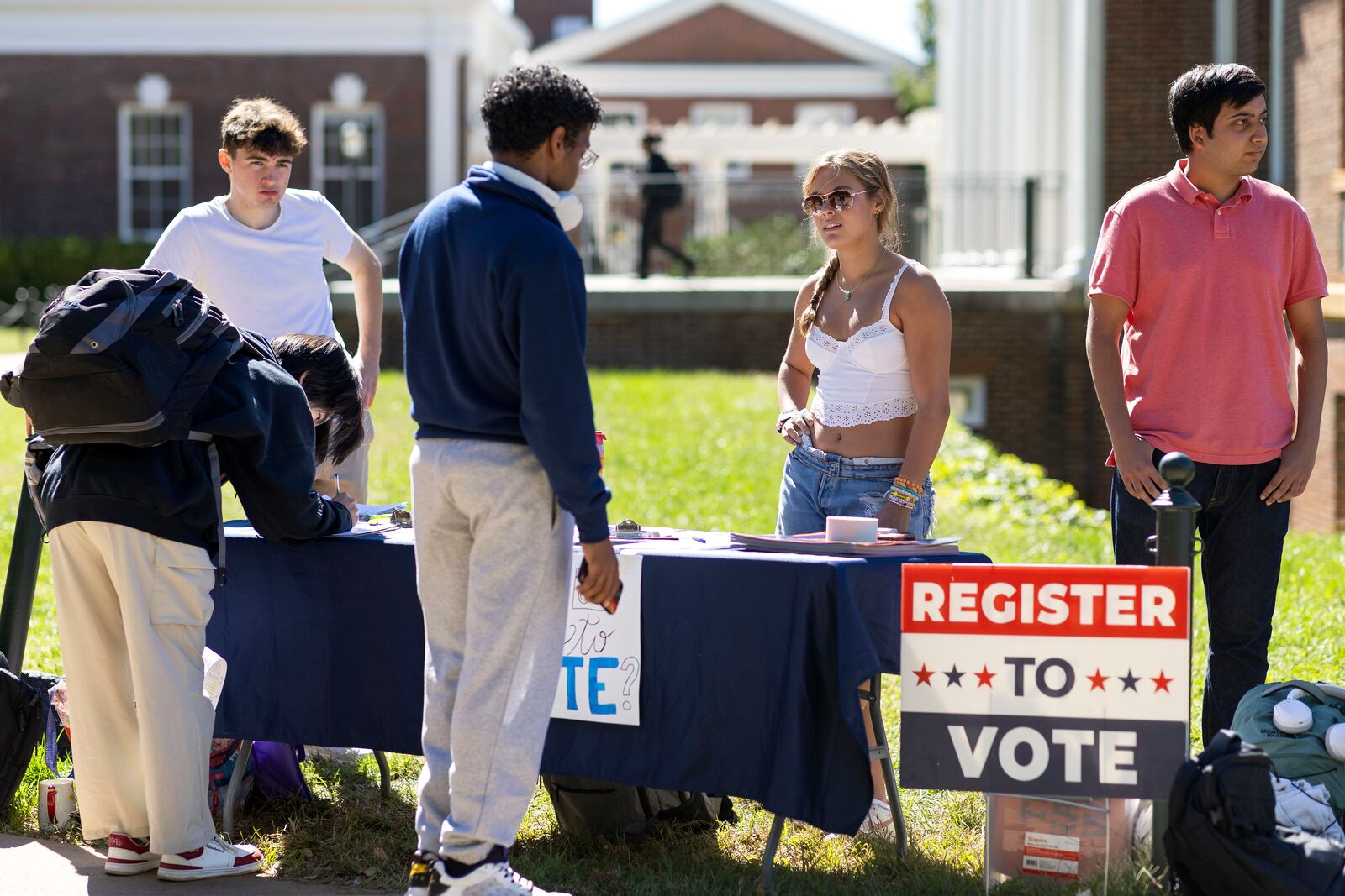 James Galvin, Charlotte Papacosma and Kushaan Soodan register students to vote at the University of Virginia in Charlottesville, Va., Friday, Oct. 11, 2024. (AP Photo/Ryan M. Kelly)