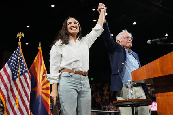 Sen. Bernie Sanders, I-Vt., and Rep. Alexandria Ocasio-Cortez, D-N.Y., greet the crowd together during a "Fighting Oligarchy" tour event at Arizona State University, Thursday, March 20, 2025, in Tempe, Ariz. (AP Photo/Ross D. Franklin)