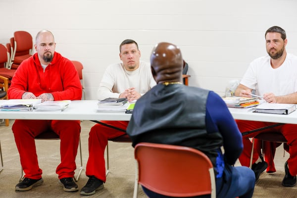 William Garner. from left, Adam Cooper and Gabriel Green listen as  motivational speaker George Simmons speaks to inmates in the Washington County Jail last month about how to stay out of incarceration in the future. (Miguel Martinez / AJC)