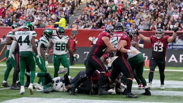 Falcons celebrate after running back Mike Davis (28) scores what proved to be the winning touchdown against the New York Jets Sunday, Oct. 10, 2021, at the Tottenham Hotspur stadium in London, England. The Falcons won 27-20. (Alastair Grant/AP)