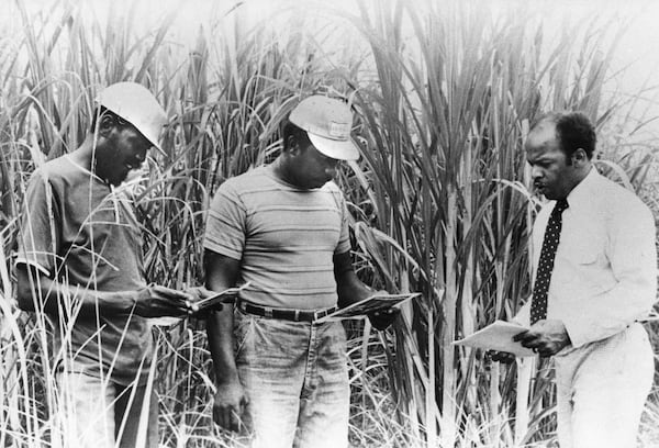 In this undated photo from the 1970s, Voter Education Project (VEP) executive director John Lewis, right, encourages black sugar cane workers in southern Louisiana to register and vote during recent statewide tour of Louisiana. (Archie E. Allen / AJC Archive at GSU Library AJCP452-150c)