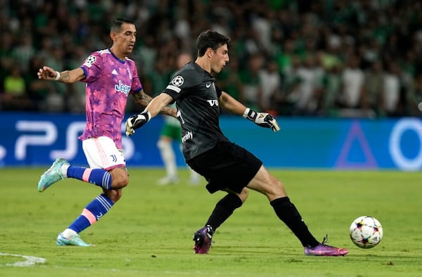 Maccabi's goalkeeper Josh Cohen kicks the ball as Juventus' Angel Di Maria tries to stop him during the group H Champions League soccer match between Maccabi Haifa and Juventus at Sammy Ofer stadium, in Haifa, Israel, Tuesday, Oct. 11, 2022. (AP Photo/Ariel Schalit)