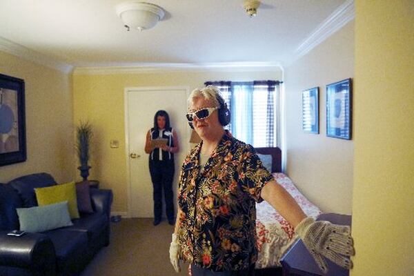 Janet Johnson feels along a wall during her turn in the Virtual Dementia Tour at Silverado Memory Care in Plano, Texas. The tour gives first responders and family a chance to understand disorientation, diminished senses and lack of awareness — all symptoms of dementia. RON BASELICE / DALLAS MORNING NEWS / TNS