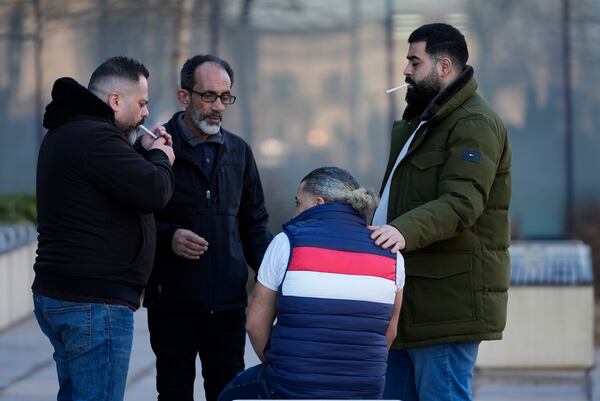 A man places a hand on Odai Alfayoumi, seated, father of six-year-old Palestinian boy Wadee Alfayoumi outside Will County Courthouse where Joseph Czuba, 73, is charged with and on trial in the fatal stabbing of the boy and the wounding of his mother Hanan Shaheen, Tuesday, Feb. 25, 2025, in Joliet, Ill. (AP Photo/Erin Hooley)