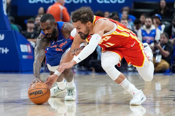 Detroit Pistons forward Tim Hardaway Jr., left, and Atlanta Hawks guard Trae Young reach for the loose ball during the first half of an NBA basketball game, Friday, Nov. 8, 2024, in Detroit. (AP Photo/Carlos Osorio)