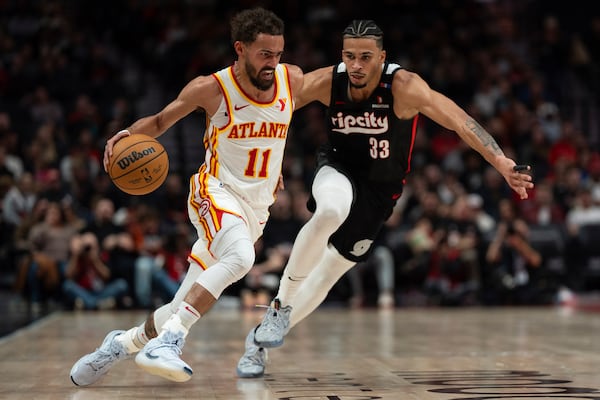 Atlanta Hawks guard Trae Young (11) drives to the basket as Portland Trail Blazers forward Toumani Camara (33) defends during the first half of an NBA basketball game Sunday, Nov. 17, 2024, in Portland, Ore. (AP Photo/Jenny Kane)