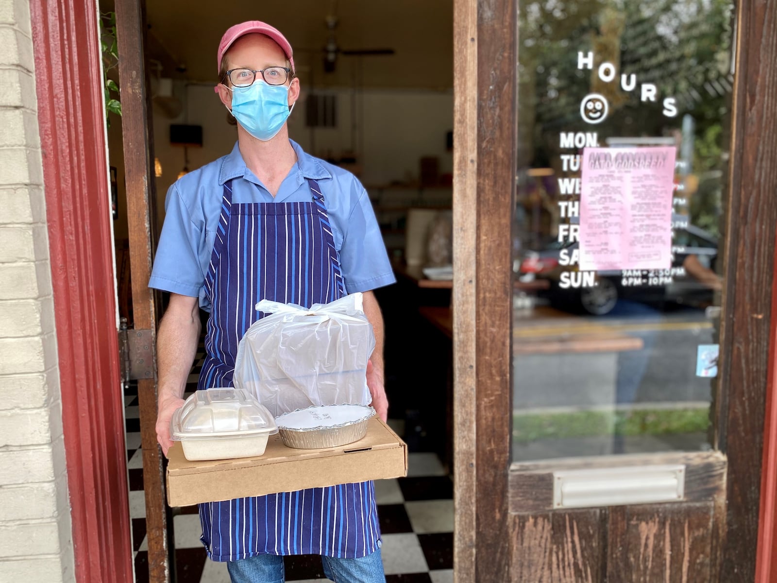 Gato chef-owner Nicholas Stinson brings a takeout order out the door of his Candler Park diner. Wendell Brock for The Atlanta Journal-Constitution