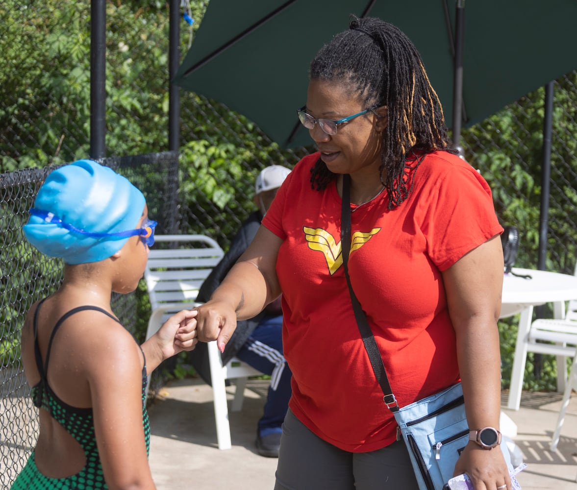 Mikesha Middlebrook (left) fist pumps her daughter, Ava, 8, after her race in a swim meet at Leslie Beach Club in Atlanta on Saturday, May 21, 2022.    According to the USA Swimming Foundation, while most Americans learn how to swim during childhood, 64% of Black children in America have little to no swimming ability. (Bob Andres / robert.andres@ajc.com)