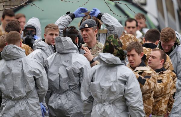 Military personnel are prepared before working to remove cars from a car park in Salisbury, England, as police and members of the armed forces probe the suspected nerve agent attack on Russian double agent spy Sergei Skripal, Sunday March 11, 2018.  