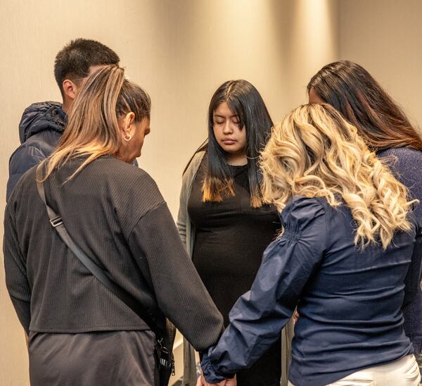 The family of 16-year-old Susana Morales pray together before a press conference Thursday in Norcross. The Gwinnett teen's remains were discovered in February, more than six months after she was reported missing. A former Doraville police officer is charged with murder and kidnapping.

(Jenni Girtman for The Atlanta Journal-Constitution)