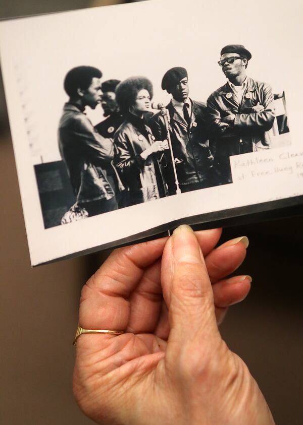 November 1, 2016 ATLANTA: Senior Lecturer and Research Fellow professor Kathleen Cleaver looks over a historical Black Panther photo taken in 1968 of  herself at the microphone during a “Free Huey Rally” along with Bobby Seal and George Murray at her Emory Law School office in 2016, .   Curtis Compton /ccompton@ajc.com