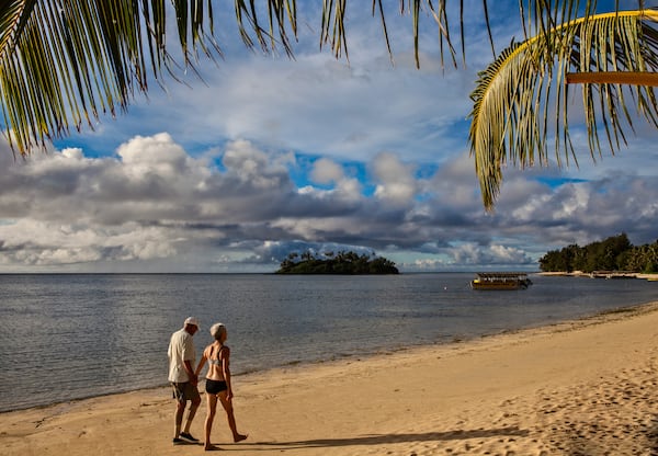 Strolling before breakfast on popular Muri Beach, with motu (islet) Taakoka and the outer reef at rear; Rarotonga, Cook Islands. (Steve Haggerty/ColorWorld/TNS)