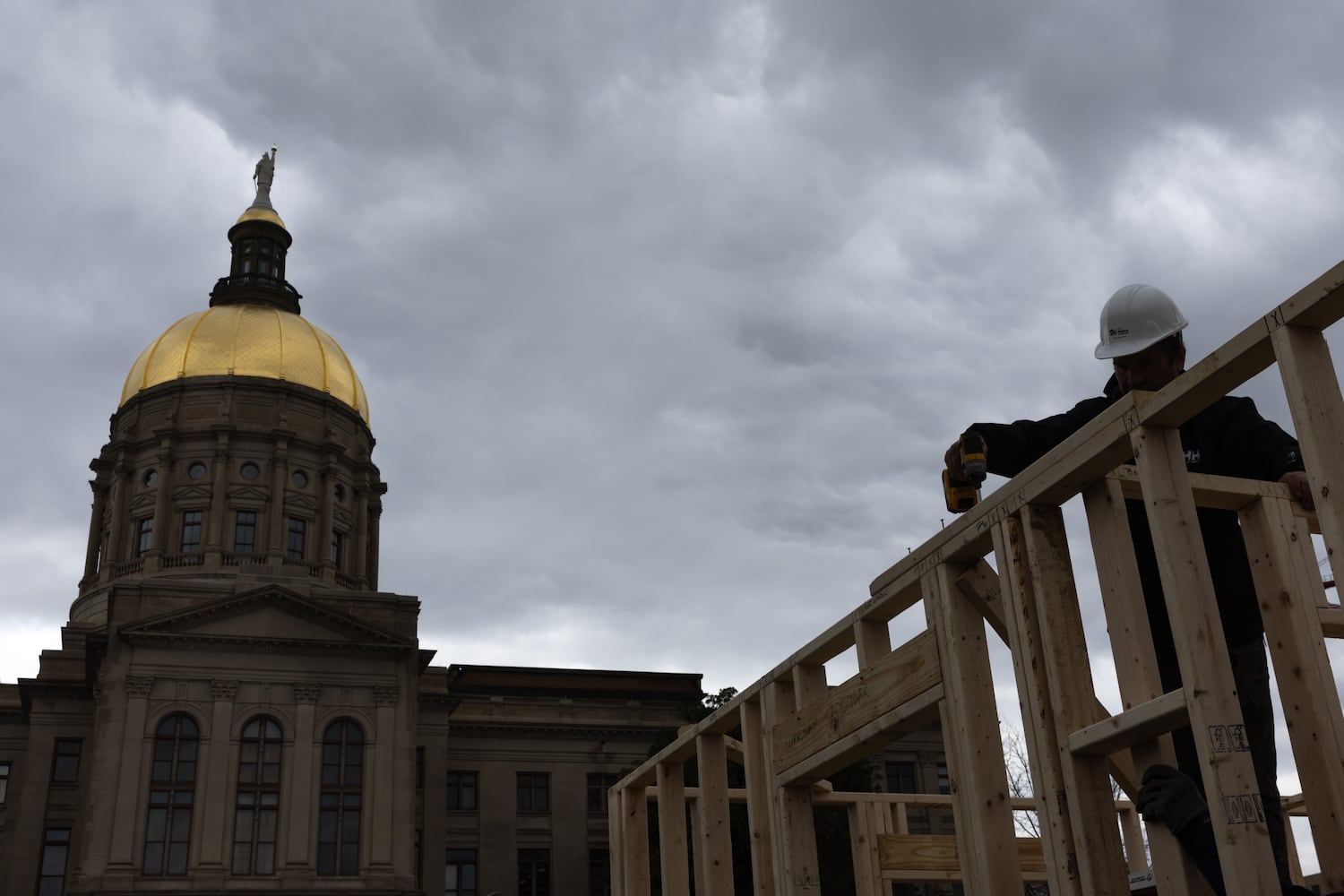 Habitat for Humanity volunteers take down the frame of a home built at Liberty Plaza, outside the Capitol, in Atlanta on Wednesday, March 5, 2025. The frame will be transported and used to house a family. (Arvin Temkar / AJC)