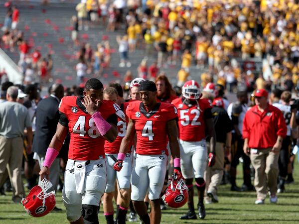  October 12, 2013 - Athens, Ga: With yellow University of Missouri fans celebrating their win in the background, Georgia Bulldogs fullback Quayvon Hicks (48) and Georgia Bulldogs cornerback Brendan Langley (4) walk off of the field after their loss at Sanford Stadium Saturday afternoon in Athens, Ga., October 12, 2013. Missouri defeated Georgia 41-26. JASON GETZ / JGETZ@AJC.COM