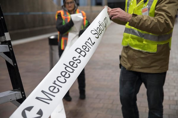 Employees of Advantage Graphics & Signs roll out the new signage that will direct attendees to Mercedes-Benz Stadium at the MARTA Dome/GWCC/Philips Arena/CNN Center Transit in Atlanta. 