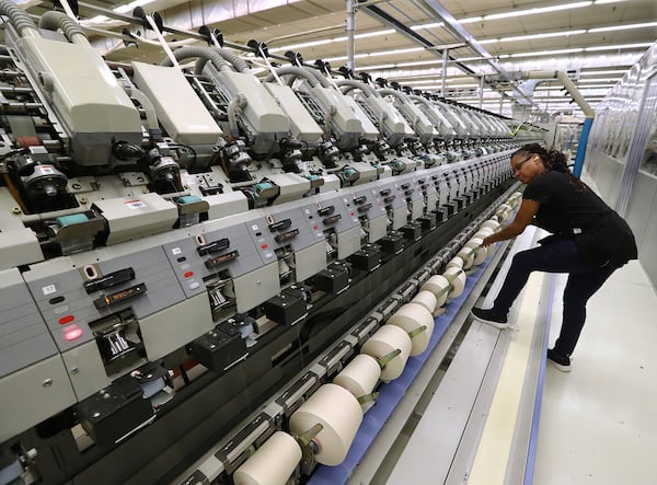 Each new generation of textile machinery is more complex than the last, making manufacturing jobs more efficient and productive. In this recent photo, operator Sandra Barfield runs a Muratec Vortex 861 spinning machine at Buhler Quality Yarns Corporation in Jefferson. Curtis Compton/ccompton@ajc.com