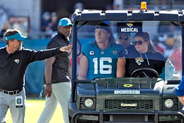 Jacksonville Jaguars quarterback Trevor Lawrence (16) leaves the field on a cart after getting injured on a late hit by Houston Texans linebacker Azeez Al-Shaair during the first half of an NFL football game Sunday, Dec. 1, 2024, in Jacksonville, Fla. (AP Photo/John Raoux)