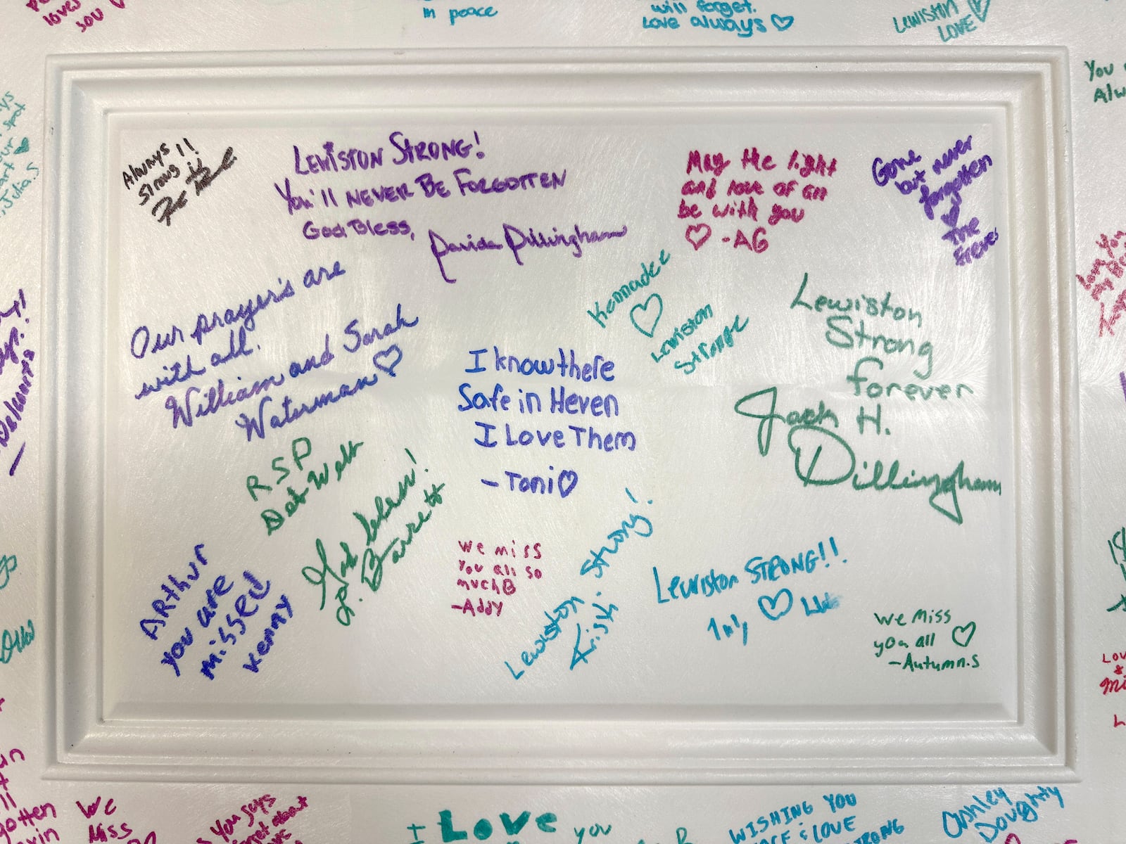 Messages are written on the cover of a time capsule at a commemoration event to mark the one year anniversary of a mass shooting in Lewiston, Maine, Friday, Oct. 25, 2024. (AP Photo/Robert F. Bukaty)