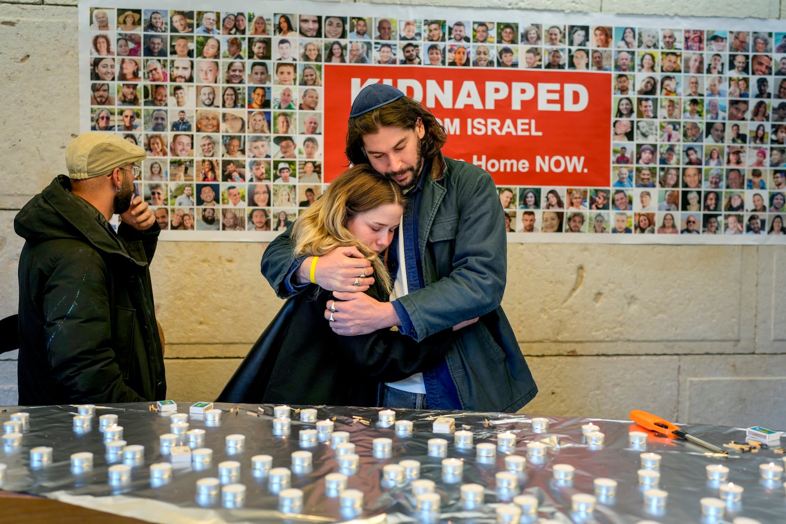 People embrace after lightning candles at a ceremony marking the first anniversary of the Hamas spearheaded attacks on Israel, at the synagogue of the Chabad community in Berlin, Germany, Monday, Oct. 7, 2024. (AP Photo/Markus Schreiber)