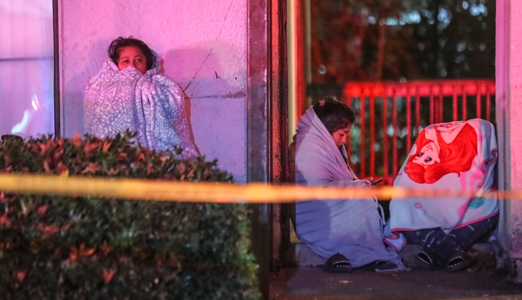 Displaced residents wait for the Red Cross in the cold. A large fire engulfed a Gwinnett County apartment building and left 49 people displaced early Wednesday morning, Nov. 1, 2023, officials said. Crews were called to the Elliot Norcross apartments overnight  and found flames bursting through the roof of a two-story building, Gwinnett fire Capt. Ryan McGiboney said. The building housed eight units. (John Spink / John.Spink@ajc.com)


