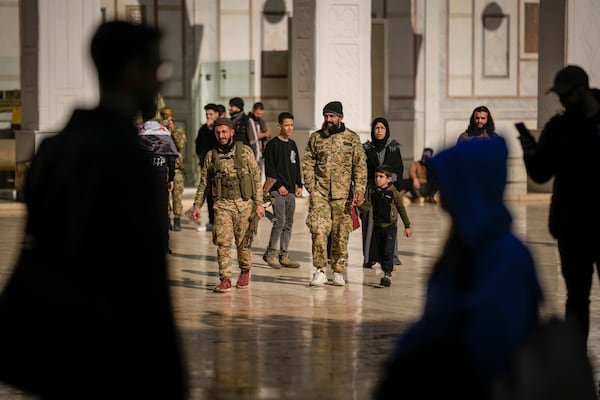 Syrian fighters on military uniform arrive at the Umayyad mosque for Friday prayers in Damascus, Syria, Friday, Dec. 12, 2024. (AP Photo/Leo Correa)