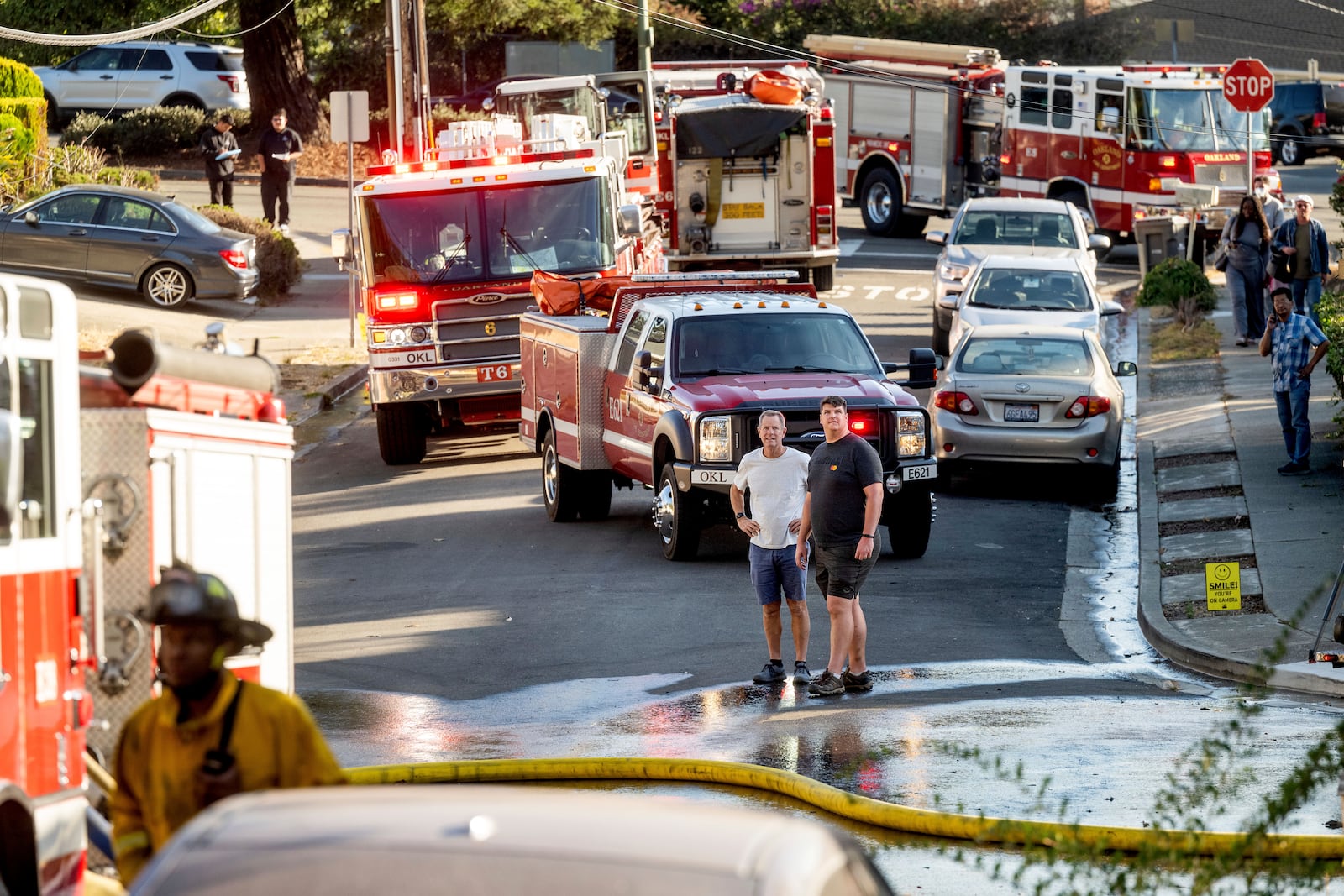 Residents watch as firefighters battle the Keller Fire burning above Interstate 580 in Oakland, Calif.,on Friday, Oct. 18, 2024. (AP Photo/Noah Berger)