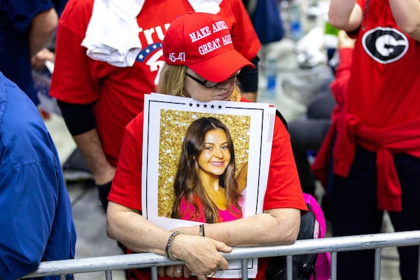 A supporter of Donald Trump holds a sign with a photo of slain nursing student Laken Riley at a rally in Rome, Ga., on March 9, 2024. Trump is expected to sign a bill bearing Riley's name that would allow detention of migrants charged with certain crimes. (Arvin Temkar/AJC 2024)