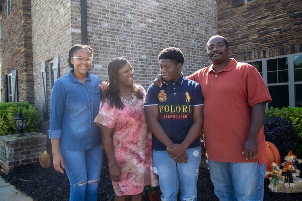 Samanthia Jordan-Hill, second from left, poses for a photo with her husband, Norman Hill, right, her daughter Kristen Jordan, left, and adopted son Christian Jordan at their residence in Newnan, Wednesday, October 7, 2020. It took the family two years to finalize Christian's adoption. (Alyssa Pointer / Alyssa.Pointer@ajc.com)