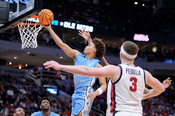 North Carolina guard Seth Trimble, top left, scores against Mississippi during the second half in the first round of the NCAA college basketball tournament, Friday, March 21, 2025, in Milwaukee, Wis. (AP Photo/Kayla Wolf)