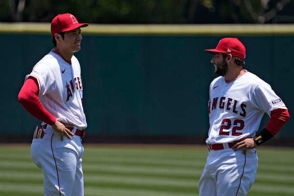 Los Angeles Angels' Shohei Ohtani, left, talks with David Fletcher as they warms up prior to a baseball game against the Arizona Diamondbacks Sunday, July 2, 2023, in Anaheim, Calif. (AP Photo/Mark J. Terrill)