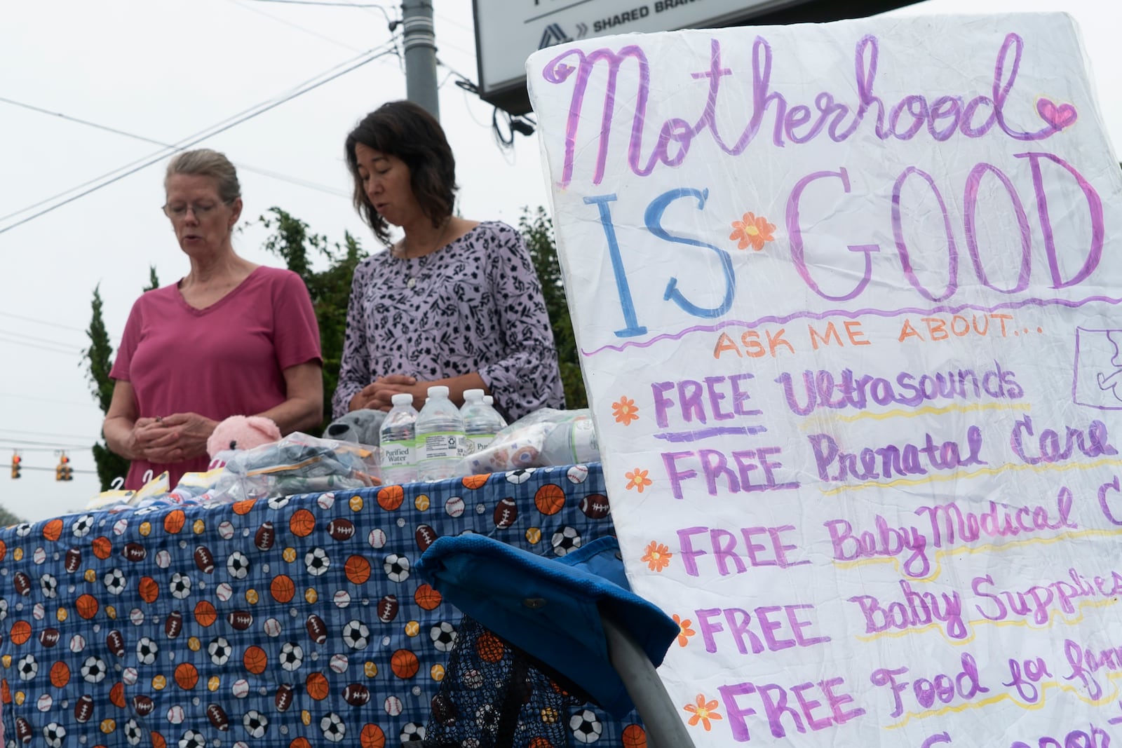 Two women pray outside a Planned Parenthood clinic in Fayetteville, N.C., on Tuesday, Oct. 1, 2024. (AP Photo/Allen G. Breed)