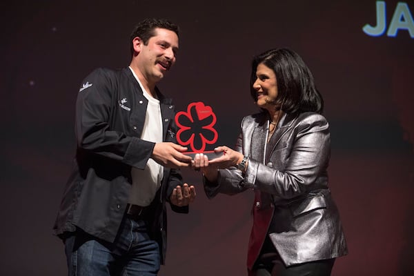 Jarrett Stieber of Little Bear restaurant receives a Young Chef award from event host Mara Davis during the Atlanta Michelin Guide gala ceremony Tuesday, Oct. 24, 2023 at the Rialto Center for the Arts in Atlanta. (Daniel Varnado/ For the AJC)