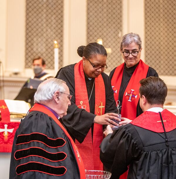 Bishop Robin Dease, right, distributes wine for communion during her installation as leader of the North Georgia Conference United Methodist Church on Sunday, Jan 8, 2023.  She is the first African-American female appointed to the position.   (Jenni Girtman for the Atlanta Journal-Constitution)