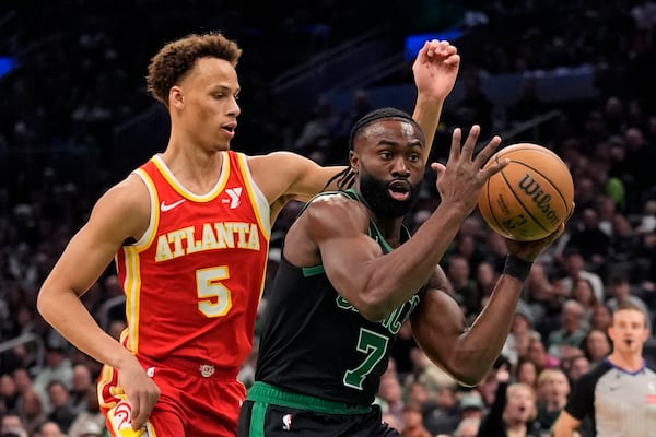 Boston Celtics' Jaylen Brown (7) moves to the net against Atlanta Hawks' Dyson Daniels (5) during the first half of an NBA basketball game, Saturday, Jan. 18, 2025, in Boston. (AP Photo/Robert F. Bukaty)