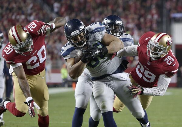 Seattle Seahawks tight end Tony Moeaki (88) is tackled by San Francisco 49ers defensive back Perrish Cox (20) and defensive back Chris Culliver (29) during the second quarter of an NFL football game in Santa Clara, Calif., Thursday, Nov. 27, 2014. (AP Photo/Marcio Jose Sanchez)