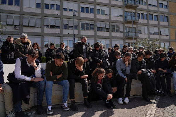 People pray outside the Agostino Gemelli Polyclinic in Rome, Sunday, Feb. 23, 2025, where Pope Francis is hospitalized since Feb. 14. (AP Photo/Gregorio Borgia)