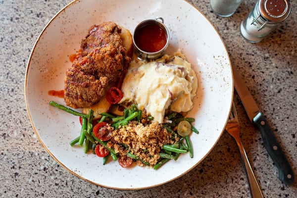 Nashville Hot Portobello, a crispy buttermilk-battered portobello mushroom, mashed potatoes,  green beans, heirloom tomatoes, almond-walnut crumble and housemade hot sauce. Photo redit- Mia Yakel.