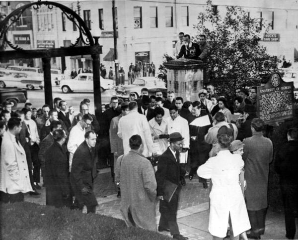 As Charlayne Hunter, 18, and Hamilton Holmes, 19, in the white coats, arrived to register as the first Black students at the University of Georgia in 1961, Vernon Jordan, the tall man behind Hunter, helped escort them, through a crowd. Jordan was a young lawyer working with the team that broke the racial barriers that kept Black students out of the formerly all white university.