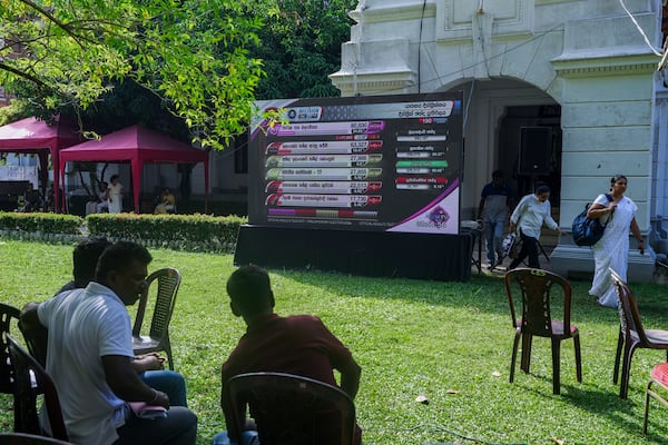 People watch polling results displayed on a giant screen outside a vote counting center following the parliamentary election in Colombo, Sri Lanka, Friday, Nov. 15, 2024. (AP Photo/Eranga Jayawardena)