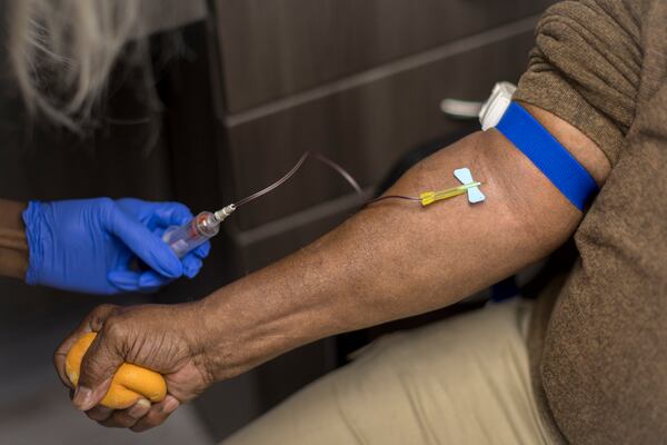 A phlebotomist takes a blood sample from John Smith as part of an Emory University pollution exposure study. Smith grew up a few blocks from the Hercules factory and his father worked in the plant for 42 years. (AJC Photo/Stephen B. Morton)