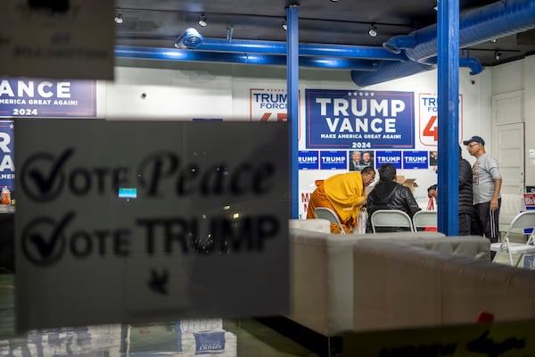 A sign hangs in the window as volunteers meet in the campaign office for Republican presidential nominee former President Donald Trump, Monday, Nov. 4, 2024, in Hamtramck, Mich. (AP Photo/David Goldman)