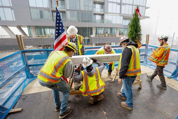 Construction workers at Centennial Yards sign a piece of the roof, marking a milestone in the construction of the Phoenix Hotel as it reached its highest point. The boutique hotel is one of six buildings under construction at Centennial Yards in downtown Atlanta.
(Miguel Martinez / AJC)