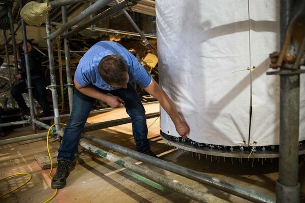 German conservator Ulrich Weilhammer talks about the process of preparing “The Battle of Atlanta” painting to be moved. The painting was separated into two 180-foot sections and rolled onto two of these 45-foot-tall spools. BRANDEN CAMP / SPECIAL