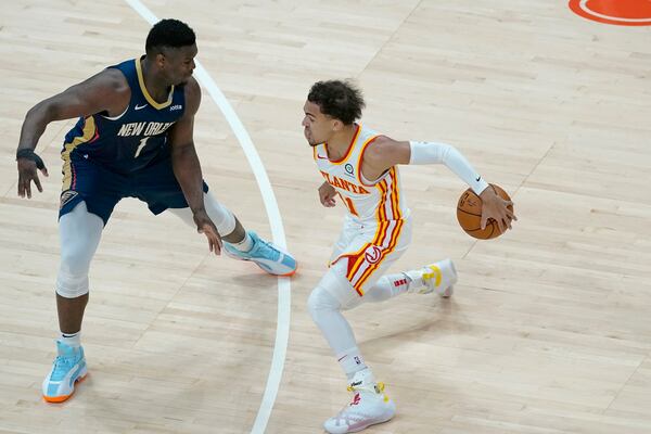 Atlanta Hawks guard Trae Young (11) works against New Orleans Pelicans forward Zion Williamson (1) in the first half of an NBA basketball game Tuesday, April 6, 2021, in Atlanta. (AP Photo/John Bazemore)