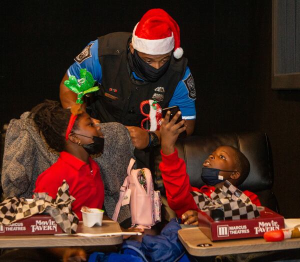 Harmony Raji (from left), Officer Dashawn Thomas and Keius Upshaw chat during Friday's event.