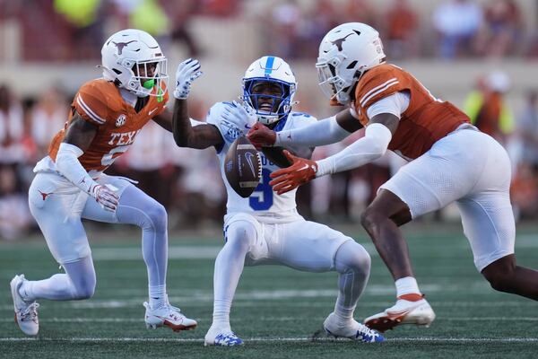 Kentucky wide receiver Ja'Mori Maclin (9) bobbles a pass as he is defended by Texas defensive back Gavin Holmes, left, and linebacker Anthony Hill Jr. (0), right, during the second half of an NCAA college football game in Austin, Texas, Saturday, Nov. 23, 2024. (AP Photo/Eric Gay)