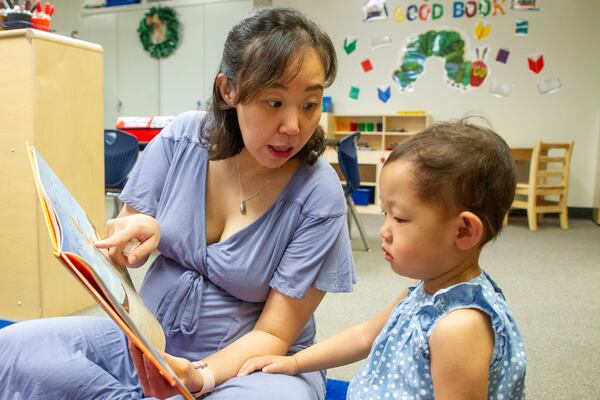 Hae Park reads to her daughter Skylar Hyum at B.B. Harris Elementary school in Duluth Friday May 13, 2022. (Steve Schaefer / steve.schaefer@ajc.com)