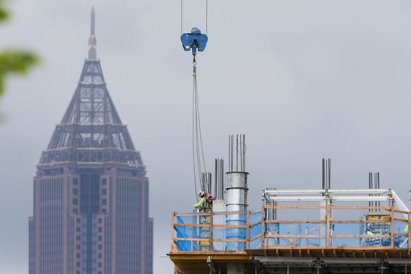 Construction workers work next to Ponce City Market with Bank of America Plaza seen in the background during an overcast day on Tuesday, July 12, 2022, in Atlanta. (Chris Day/Christopher.Day@ajc.com)